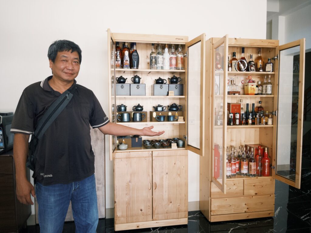 一個人正在展示他的酒櫃,收藏他的茶具與酒